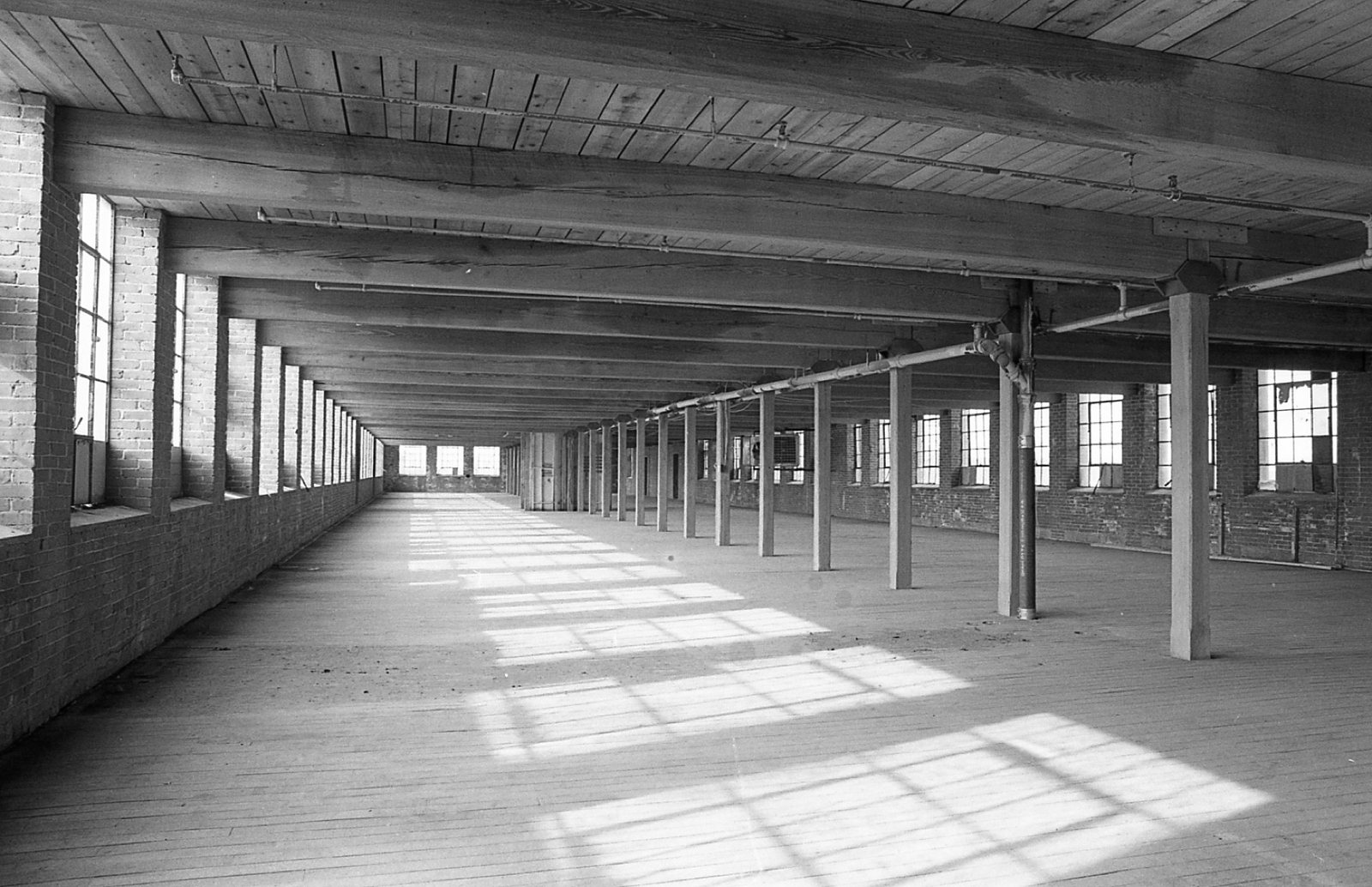 An empty mill floor with sunlight through the windows, 1980