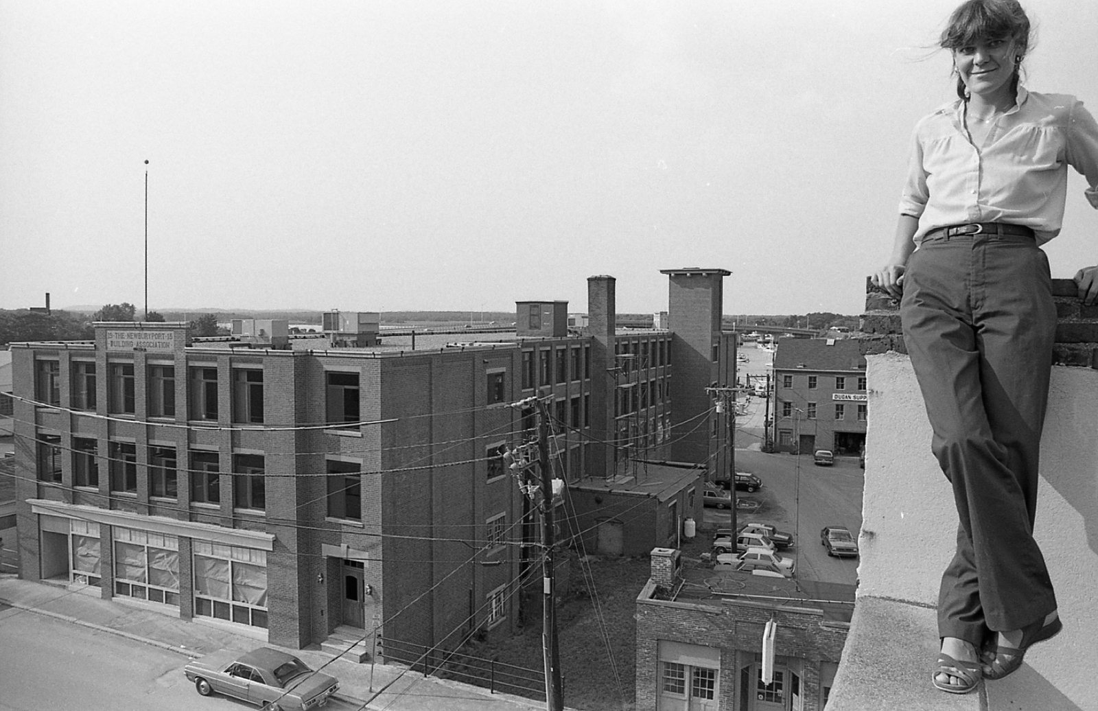 Janet Tracy on the roof parapet with the building behind her, about 1980