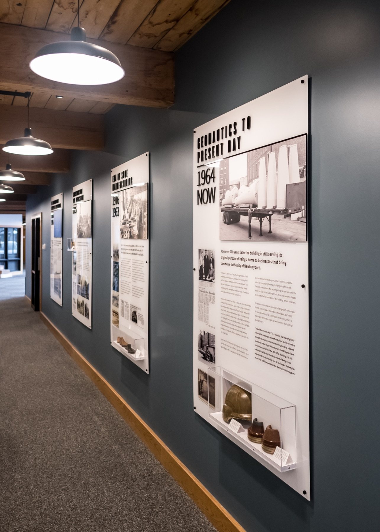 Lobby timeline panels — Geonautics to present day, with a PASGT helmet and shoe lasts on display